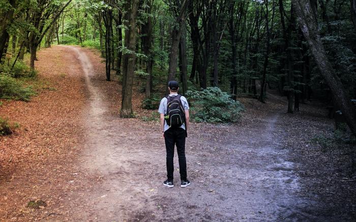 man standing in the middle of woods by Vladislav Babienko courtesy of Unsplash.