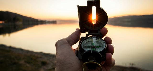 person showing black and white compass by Tim Graf courtesy of Unsplash.